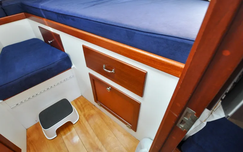 Slide: The Image of 1958 Bunker and Ellis 42 | Aleria Interior of 1958 Bunker and Ellis 42 boat with blue cushions and wooden cabinetry. - 6307508