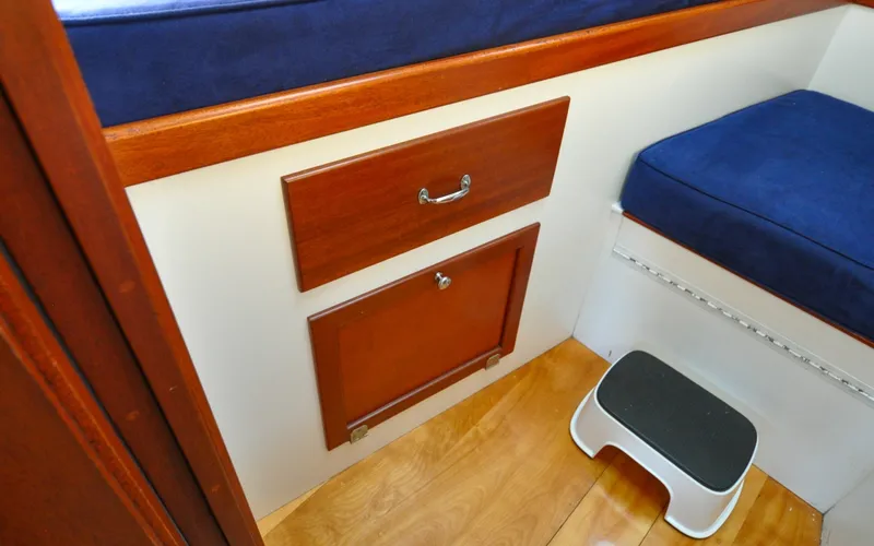 Slide: The Image of 1958 Bunker and Ellis 42 | Aleria Interior of 1958 Bunker and Ellis 42 boat with wooden cabinetry and blue seating. - 6307509