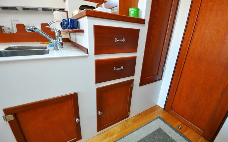 Slide: The Image of 1958 Bunker and Ellis 42 | Aleria Interior of 1958 Bunker and Ellis 42 boat with wooden cabinetry and sink. - 6307517