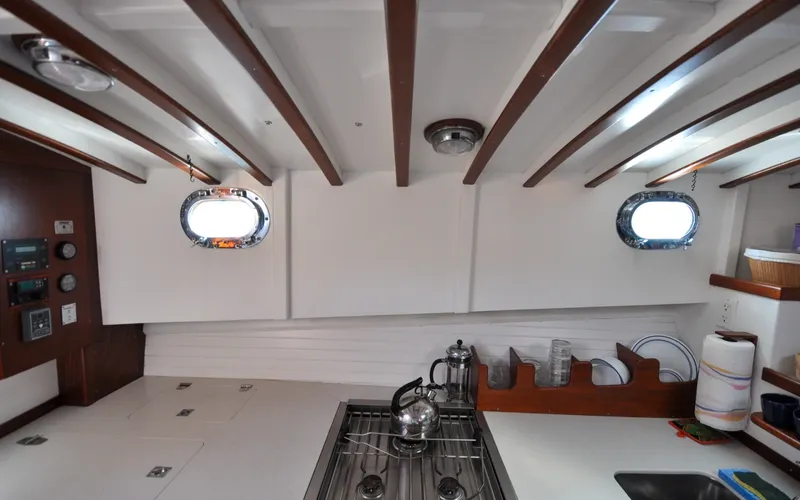Slide: The Image of 1958 Bunker and Ellis 42 | Aleria Interior of a 1958 Bunker and Ellis 42 boat, featuring a classic kitchen setup. - 6307542