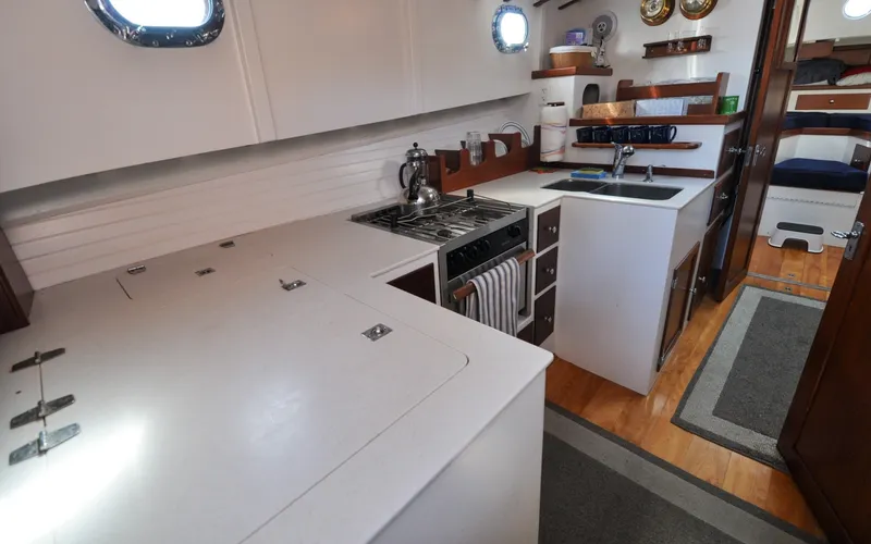 Slide: The Image of 1958 Bunker and Ellis 42 | Aleria Interior of a 1958 Bunker and Ellis 42 boat, featuring a compact kitchen area. - 6307524