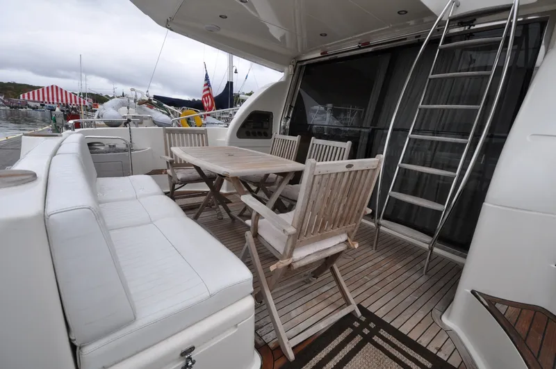 Slide: The Image of 1996 Azimut 54 | Calmati Outdoor seating area on 1996 Azimut Cinquantaquattro yacht with wooden table and chairs. - 6308558