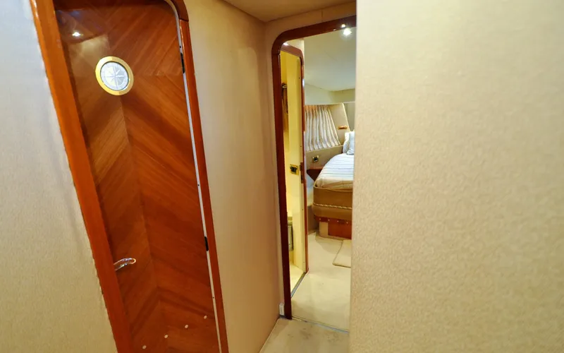 Slide: The Image of 1996 Azimut 54 | Calmati Interior hallway of 1996 Azimut Cinquantaquattro yacht, featuring wood paneling and bedroom view. - 6308942