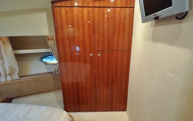 Slide: The Image of 1996 Azimut 54 | Calmati Luxurious interior of 1996 Azimut Cinquantaquattro yacht with wood cabinetry and porthole window. - 6308945