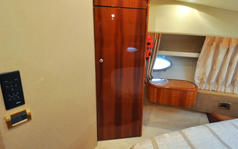 Slide: The Image of 1996 Azimut 54 | Calmati Luxurious interior of 1996 Azimut Cinquantaquattro yacht with wood finishes and porthole window. - 6308948