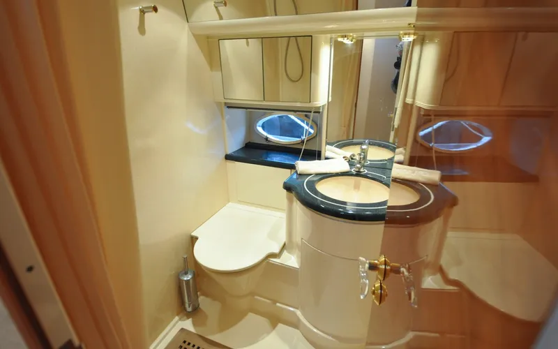 Slide: The Image of 1996 Azimut 54 | Calmati Luxurious bathroom in 1996 Azimut Cinquantaquattro yacht with elegant fixtures and porthole window. - 6308957