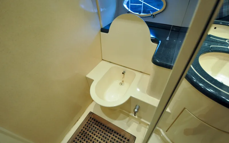 Slide: The Image of 1996 Azimut 54 | Calmati Bathroom interior of 1996 Azimut Cinquantaquattro yacht, featuring a compact sink and porthole window. - 6308955