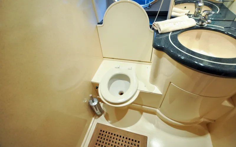 Slide: The Image of 1996 Azimut 54 | Calmati Bathroom interior of 1996 Azimut Cinquantaquattro yacht, featuring compact toilet and sink. - 6308956