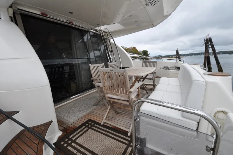 Slide: The Image of 1996 Azimut 54 | Calmati 1996 Azimut Cinquantaquattro yacht deck with wooden furniture and scenic water view. - 6308556