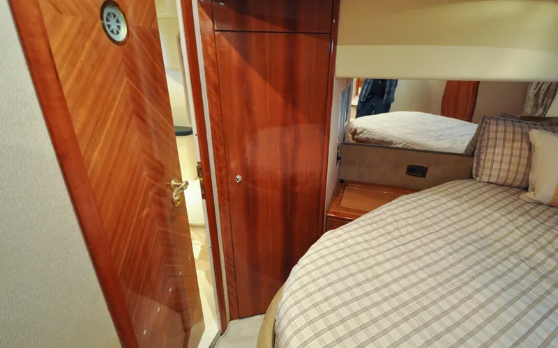 Slide: The Image of 1996 Azimut 54 | Calmati Luxurious 1996 Azimut Cinquantaquattro yacht interior with wood paneling and cozy bedroom. - 6308977