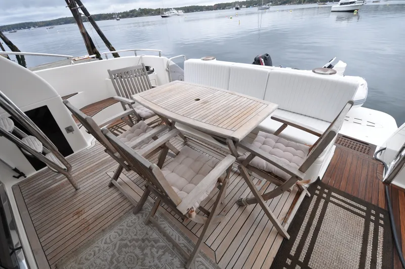 Slide: The Image of 1996 Azimut 54 | Calmati Luxury Azimut Cinquantaquattro 1996 yacht deck with wooden furniture and scenic water view. - 6308563