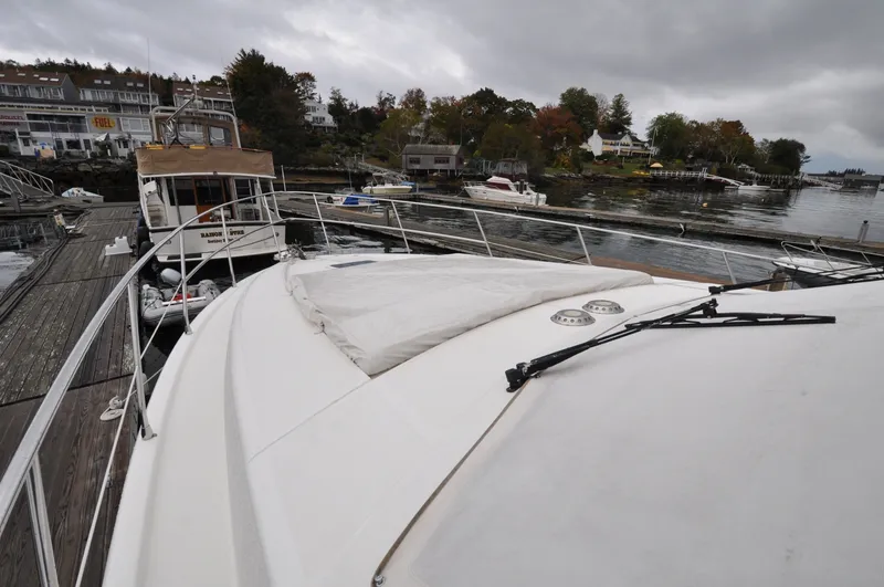 Slide: The Image of 1996 Azimut 54 | Calmati 1996 Azimut Cinquantaquattro yacht docked at a marina, showcasing sleek deck design. - 6308588