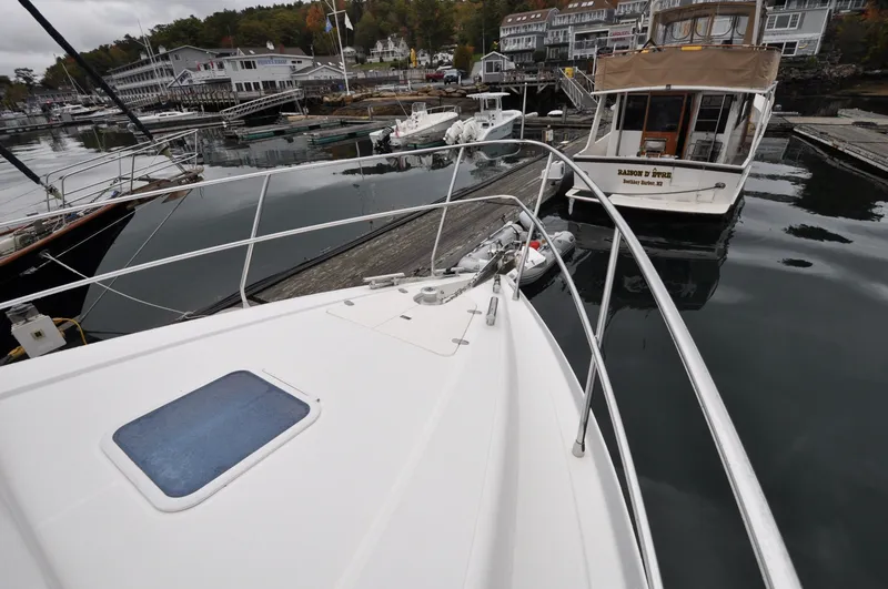 Slide: The Image of 1996 Azimut 54 | Calmati 1996 Azimut Cinquantaquattro yacht bow view at marina, showcasing sleek design and railing. - 6308587