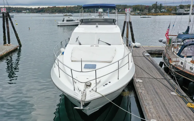 Slide: The Image of 1996 Azimut 54 | Calmati 1996 Azimut Cinquantaquattro yacht docked at a marina, surrounded by calm waters. - 6308524