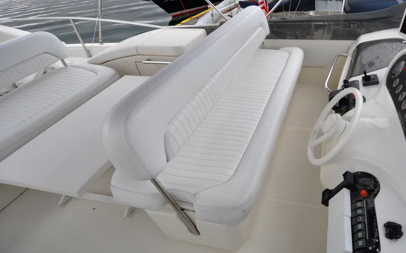 Slide: The Image of 1996 Azimut 54 | Calmati 1996 Azimut Cinquantaquattro yacht interior with white seating and steering wheel. - 6308892