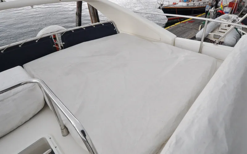 Slide: The Image of 1996 Azimut 54 | Calmati 1996 Azimut Cinquantaquattro yacht deck with cushioned seating area. - 6308914