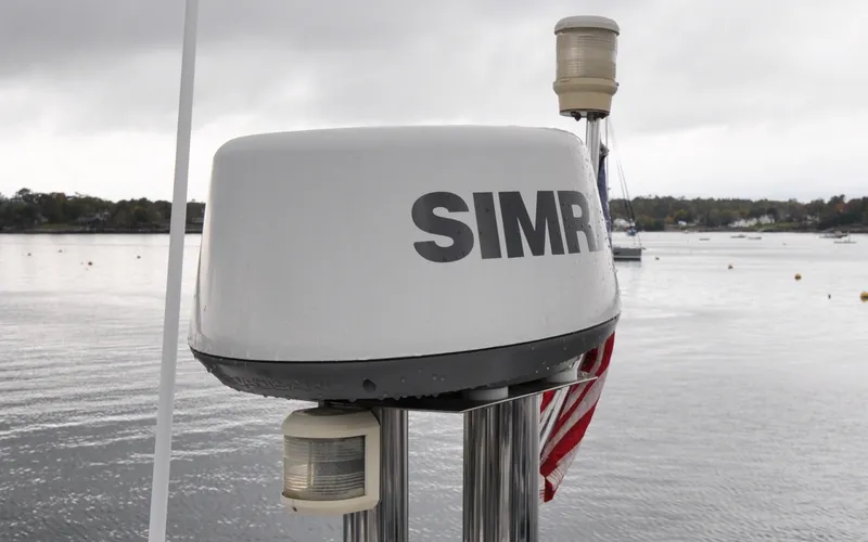 Slide: The Image of 1996 Azimut 54 | Calmati Radar equipment on 1996 Azimut Cinquantaquattro yacht, with American flag and water backdrop. - 6308910