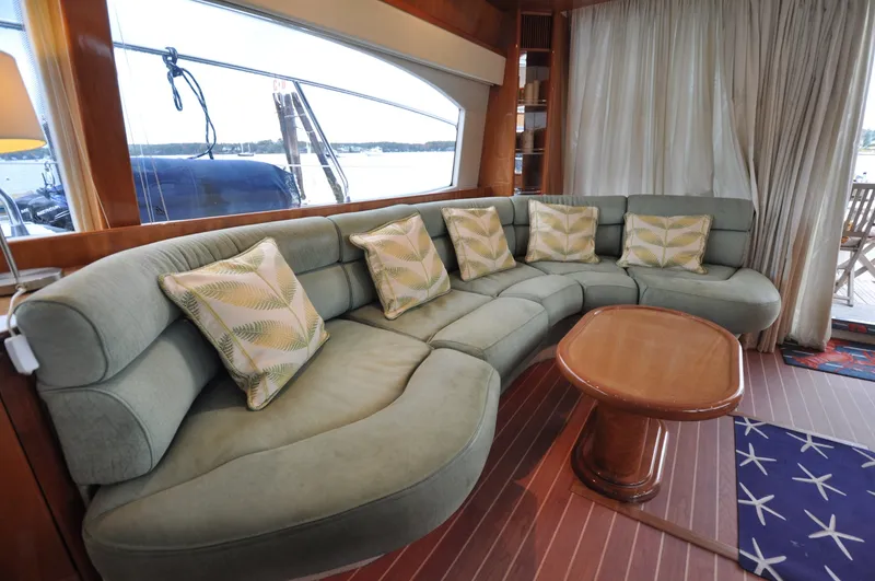 Slide: The Image of 1996 Azimut 54 | Calmati Luxurious Azimut Cinquantaquattro 1996 yacht interior with curved sofa and decorative pillows. - 6308611