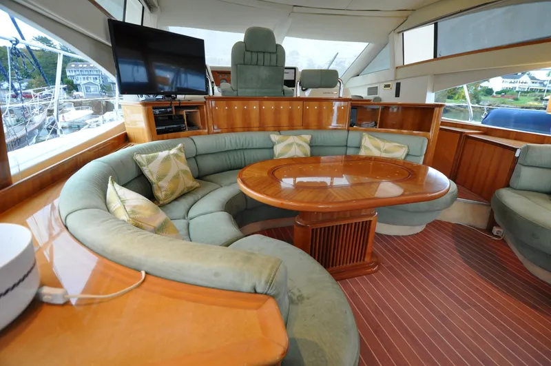 Slide: The Image of 1996 Azimut 54 | Calmati Luxurious interior of 1996 Azimut Cinquantaquattro yacht with curved seating and wooden table. - 6308616