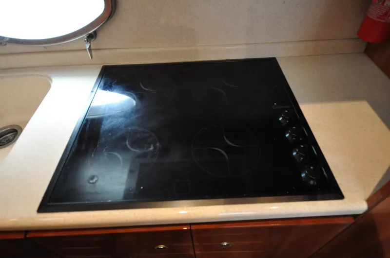 Slide: The Image of 1996 Azimut 54 | Calmati Kitchen sink area on 1996 Azimut Cinquantaquattro yacht, featuring dual basins and a porthole window. - 6308631