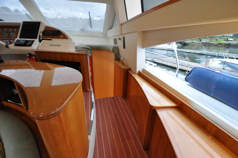 Slide: The Image of 1996 Azimut 54 | Calmati Interior of 1996 Azimut Cinquantaquattro yacht with polished wood finish and marina view. - 6308640