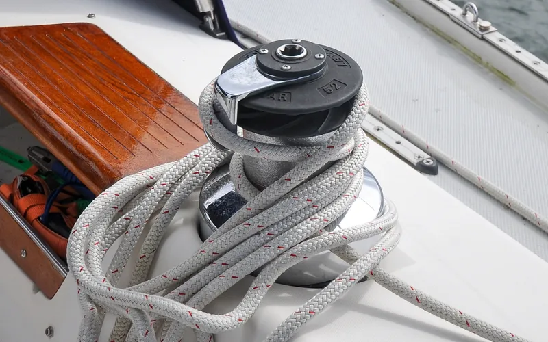 Slide: The Image of 1993 Catalina 42 | Kanga Winch with rope on 1993 Catalina 42 sailboat deck, featuring wooden trim. - 6318884
