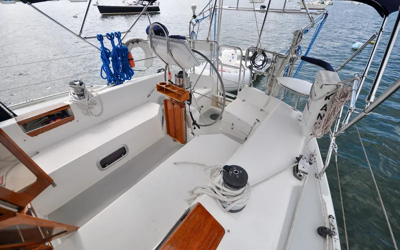 Slide: The Image of 1993 Catalina 42 | Kanga Cockpit of a 1993 Catalina 42 sailboat with ropes and winches, docked on calm water. - 6318894
