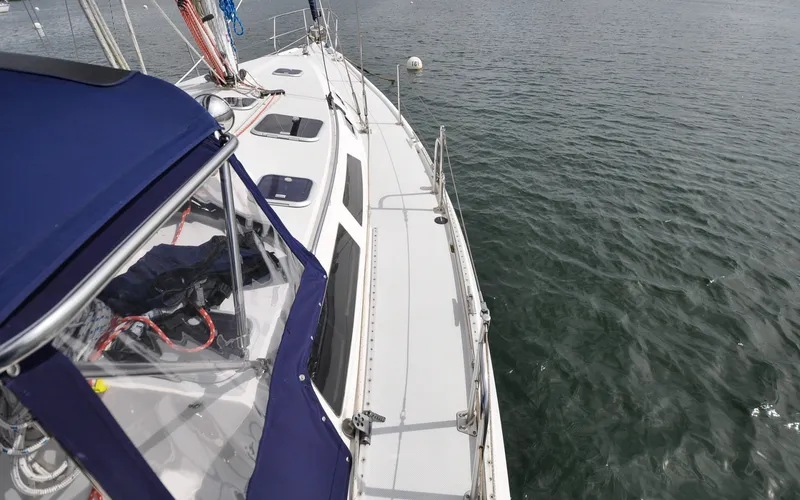 Slide: The Image of 1993 Catalina 42 | Kanga Sailboat Catalina 42, 1993 model, on calm water with blue canopy and deck view. - 6318858
