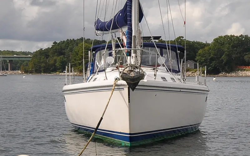 Slide: The Image of 1993 Catalina 42 | Kanga Front view of a 1993 Catalina 42 sailboat anchored in a scenic harbor. - 6318826