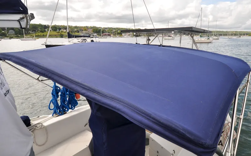 Slide: The Image of 1993 Catalina 42 | Kanga Blue canopy on 1993 Catalina 42 sailboat, docked in a scenic harbor. - 6318869