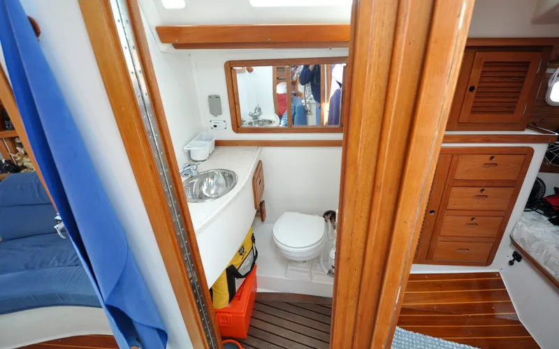 Slide: The Image of 1993 Catalina 42 | Kanga Interior of 1993 Catalina 42 sailboat bathroom with wooden cabinetry and compact design. - 6318938