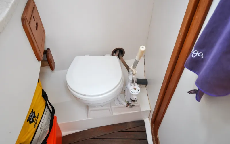 Slide: The Image of 1993 Catalina 42 | Kanga 1993 Catalina 42 yacht bathroom with marine toilet and wooden flooring. - 6318944