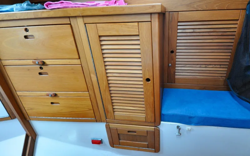 Slide: The Image of 1993 Catalina 42 | Kanga Wooden cabinetry and blue cushion in 1993 Catalina 42 sailboat interior. - 6318898