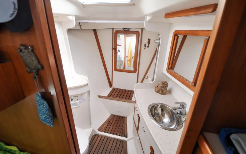 Slide: The Image of 1993 Catalina 42 | Kanga Interior of 1993 Catalina 42 sailboat bathroom with wooden accents and stainless steel sink. - 6318901