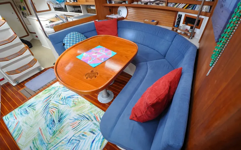 Slide: The Image of 1993 Catalina 42 | Kanga Interior of 1993 Catalina 42 sailboat with blue seating and wooden table. - 6318924
