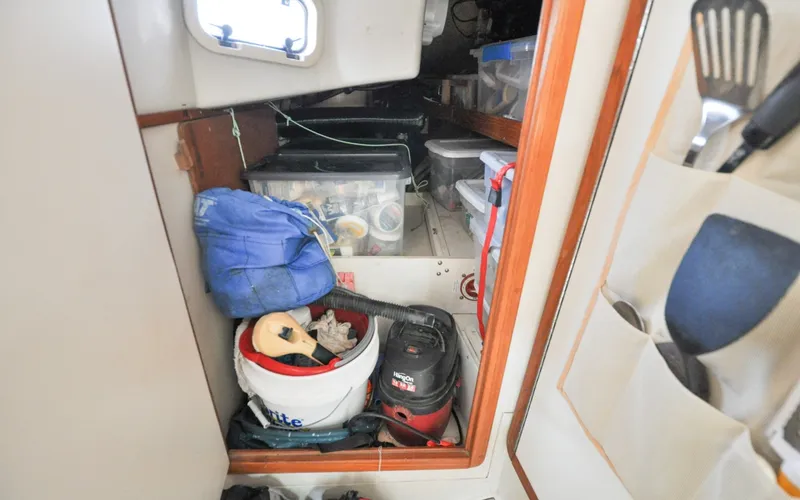 Slide: The Image of 1993 Catalina 42 | Kanga Storage area inside a 1993 Catalina 42 sailboat with various tools and equipment. - 6318935