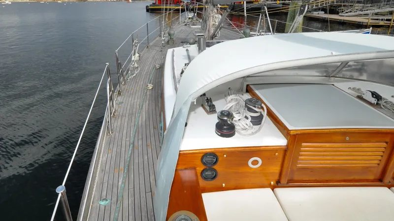 Slide: The Image of 1987 Wittholtz/Luzier 49 | Destiny 1987 Custom Wittholtz/Luzier Sloop/Cutter deck with winches and ropes, docked by calm water. - 6318995