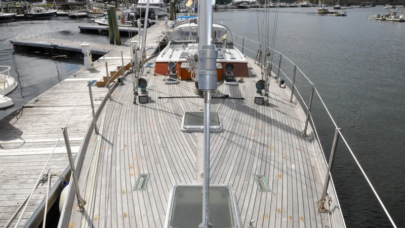 Slide: The Image of 1987 Wittholtz/Luzier 49 | Destiny 1987 Custom Wittholtz/Luzier Sloop/Cutter docked, showcasing wooden deck and marina backdrop. - 6319004