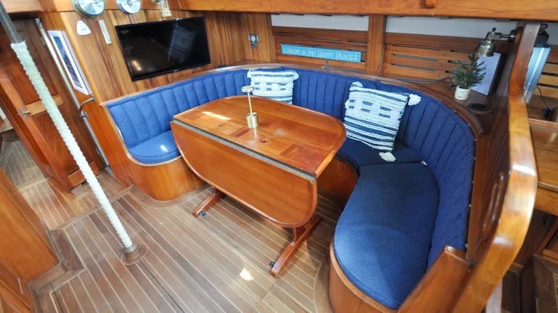 Slide: The Image of 1987 Wittholtz/Luzier 49 | Destiny Cozy 1987 Custom Wittholtz/Luzier Sloop/Cutter interior with blue seating and wooden table. - 6319010