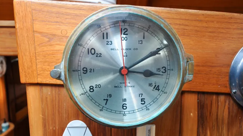 Slide: The Image of 1987 Wittholtz/Luzier 49 | Destiny Vintage ship's bell clock on 1987 Wittholtz/Luzier Sloop/Cutter, wooden background. - 6319011