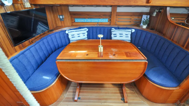 Slide: The Image of 1987 Wittholtz/Luzier 49 | Destiny Cozy wooden interior of 1987 Wittholtz/Luzier Sloop with blue cushioned seating and table. - 6319015
