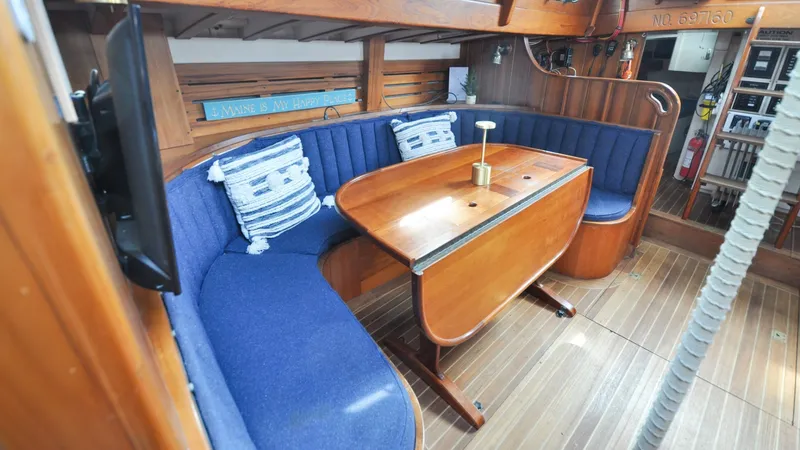 Slide: The Image of 1987 Wittholtz/Luzier 49 | Destiny Cozy 1987 Custom Wittholtz/Luzier Sloop/Cutter interior with blue seating and wooden table. - 6319016