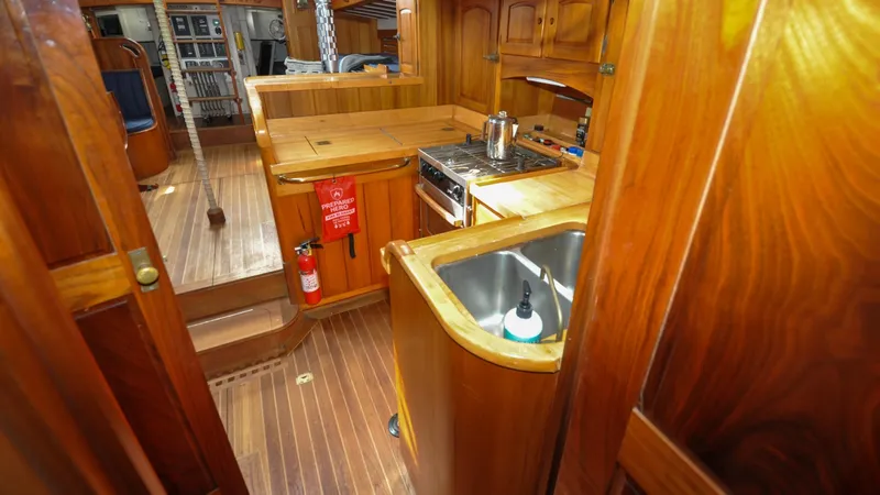 Slide: The Image of 1987 Wittholtz/Luzier 49 | Destiny Interior of 1987 Custom Wittholtz/Luzier Sloop/Cutter with wooden cabinetry and kitchen amenities. - 6319032