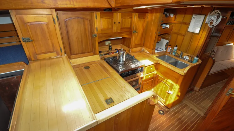 Slide: The Image of 1987 Wittholtz/Luzier 49 | Destiny 1987 Custom Wittholtz/Luzier Sloop/Cutter galley with wooden cabinetry, stove, and sink. - 6319034