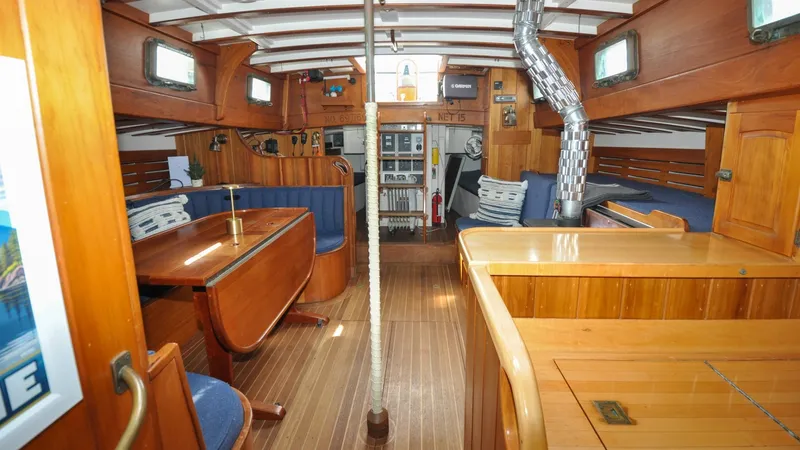 Slide: The Image of 1987 Wittholtz/Luzier 49 | Destiny Interior of 1987 Custom Wittholtz/Luzier Sloop/Cutter with wooden furnishings and blue seating. - 6319038