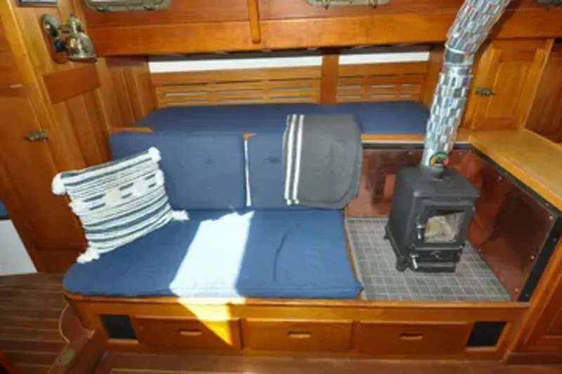 Slide: The Image of 1987 Wittholtz/Luzier 49 | Destiny Cozy 1987 Custom Wittholtz/Luzier Sloop/Cutter interior with blue seating and wood stove. - 6323962