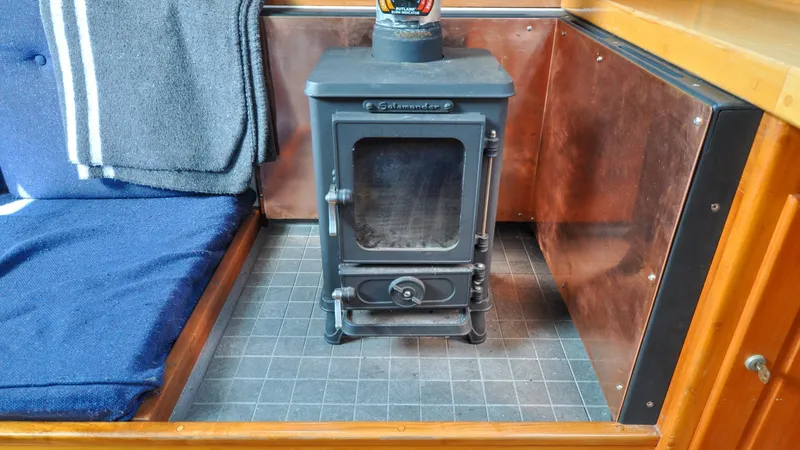 Slide: The Image of 1987 Wittholtz/Luzier 49 | Destiny Compact wood stove in a 1987 Custom Wittholtz/Luzier Sloop/Cutter interior, with cozy seating. - 6318983
