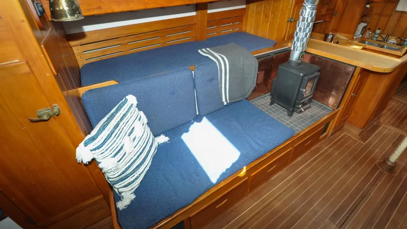 Slide: The Image of 1987 Wittholtz/Luzier 49 | Destiny Cozy 1987 Custom Wittholtz/Luzier Sloop/Cutter interior with blue seating and wood stove. - 6319043