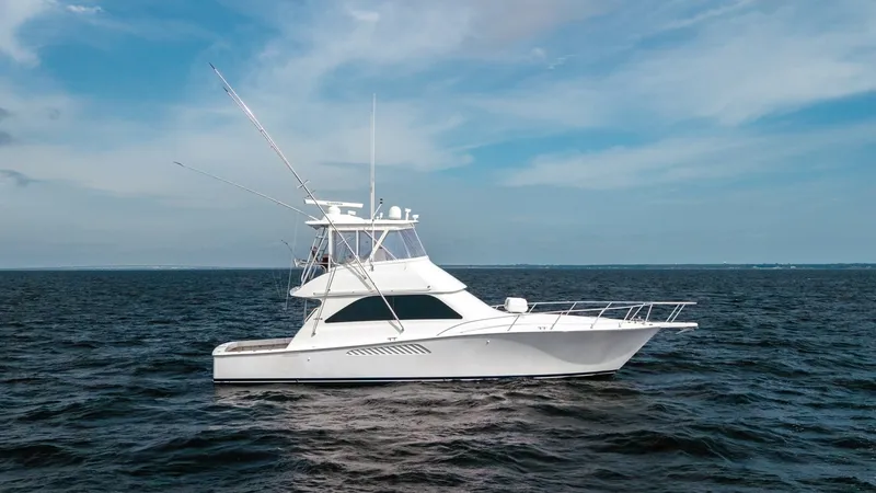 The Image of Side Profile of Viking 45 Convertible This image showcases the sleek side profile of the 2007 Viking 45 Convertible, highlighting its classic lines and robust fishing capabilities. The vessel's flybridge is equipped with a full array of antennas and radar, while the spacious cockpit is ideal - 6394716