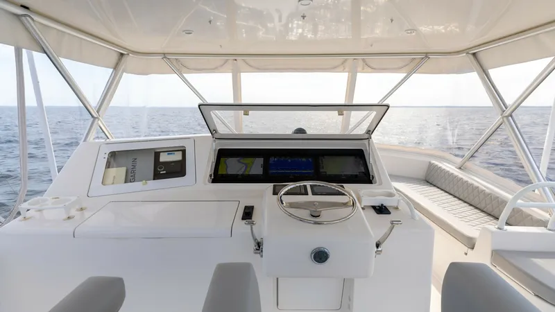Slide: The Image of Flybridge Helm with Seating The helm of the 2007 Viking 45 Convertible features a sleek, modern design with advanced navigation equipment. The expansive flybridge offers a comfortable seating area with panoramic views, perfect for navigating or relaxing at sea. The clean lines and q - 6394717